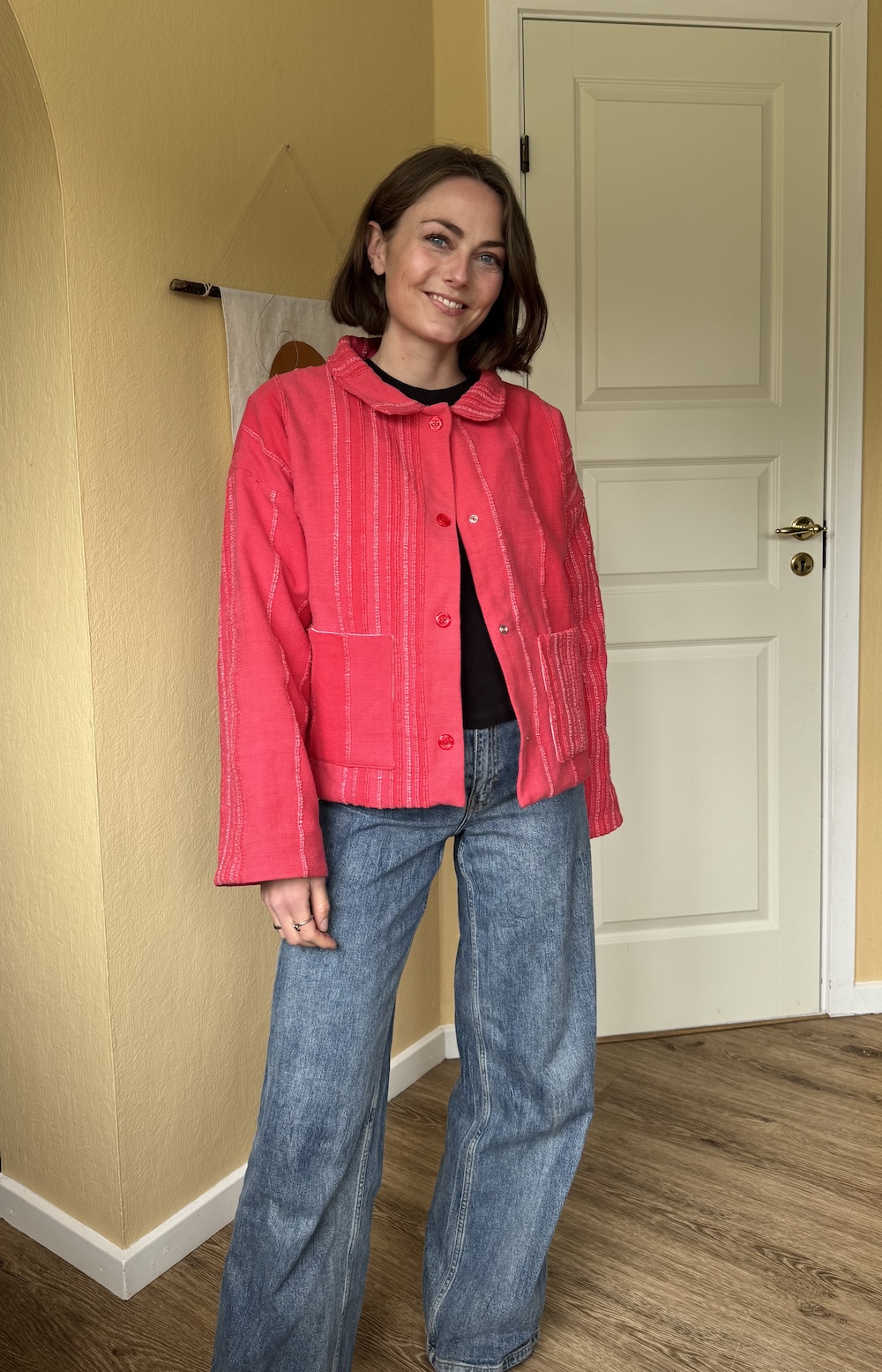 Billede af mig (kvinde) i mit jakkemønster Celia, set tæt på. Den er rød og har knapper med en lille krave.